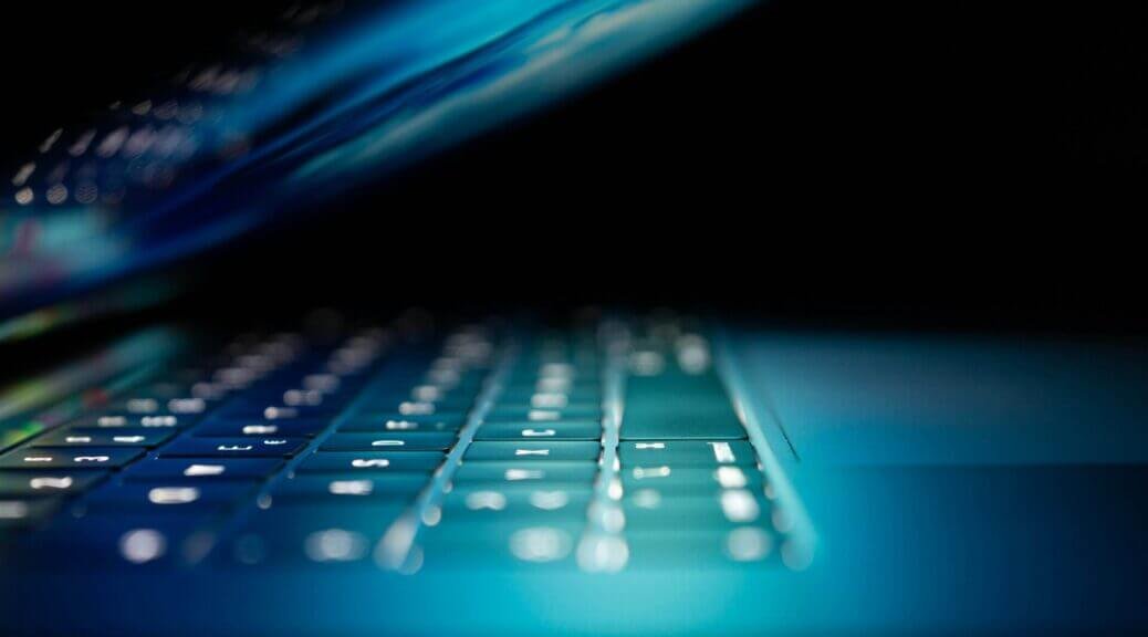 closeup photo of a laptop keyboard in the dark