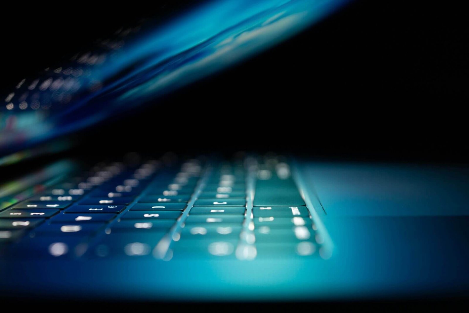 closeup photo of a laptop keyboard in the dark