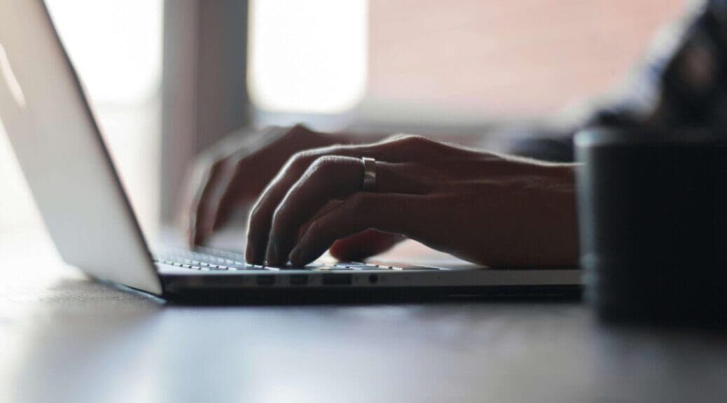hands typing on laptop keyboard
